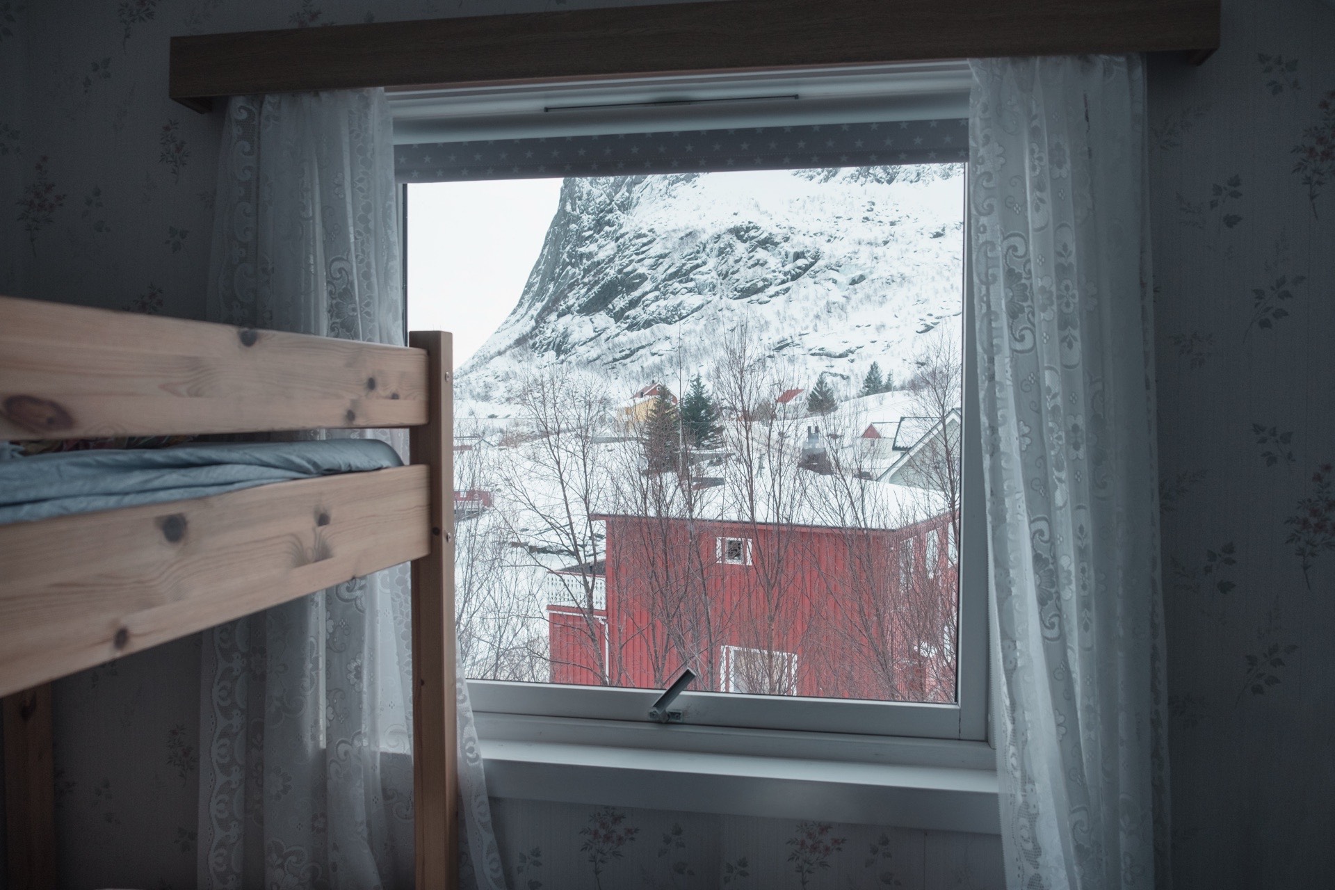 Wnętrze sypialni z oknem podczas śnieżnego dnia w Norwegii