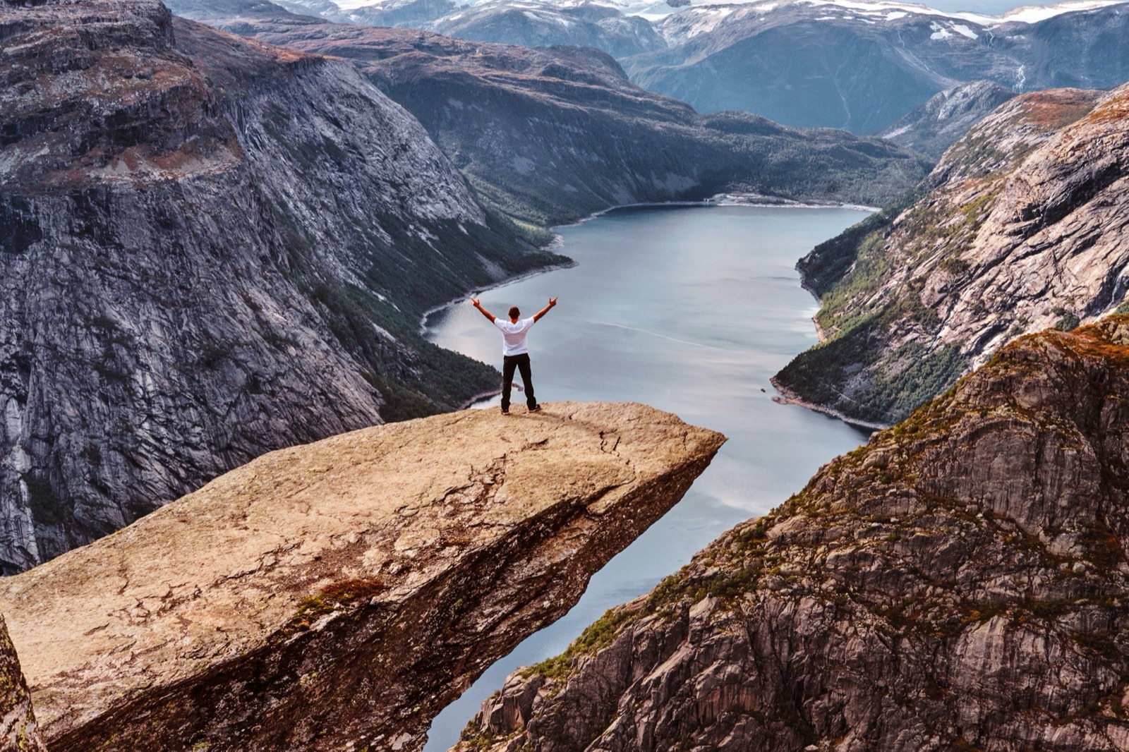 Turysta stojący na Trolltunga z widokiem na norweski fjord