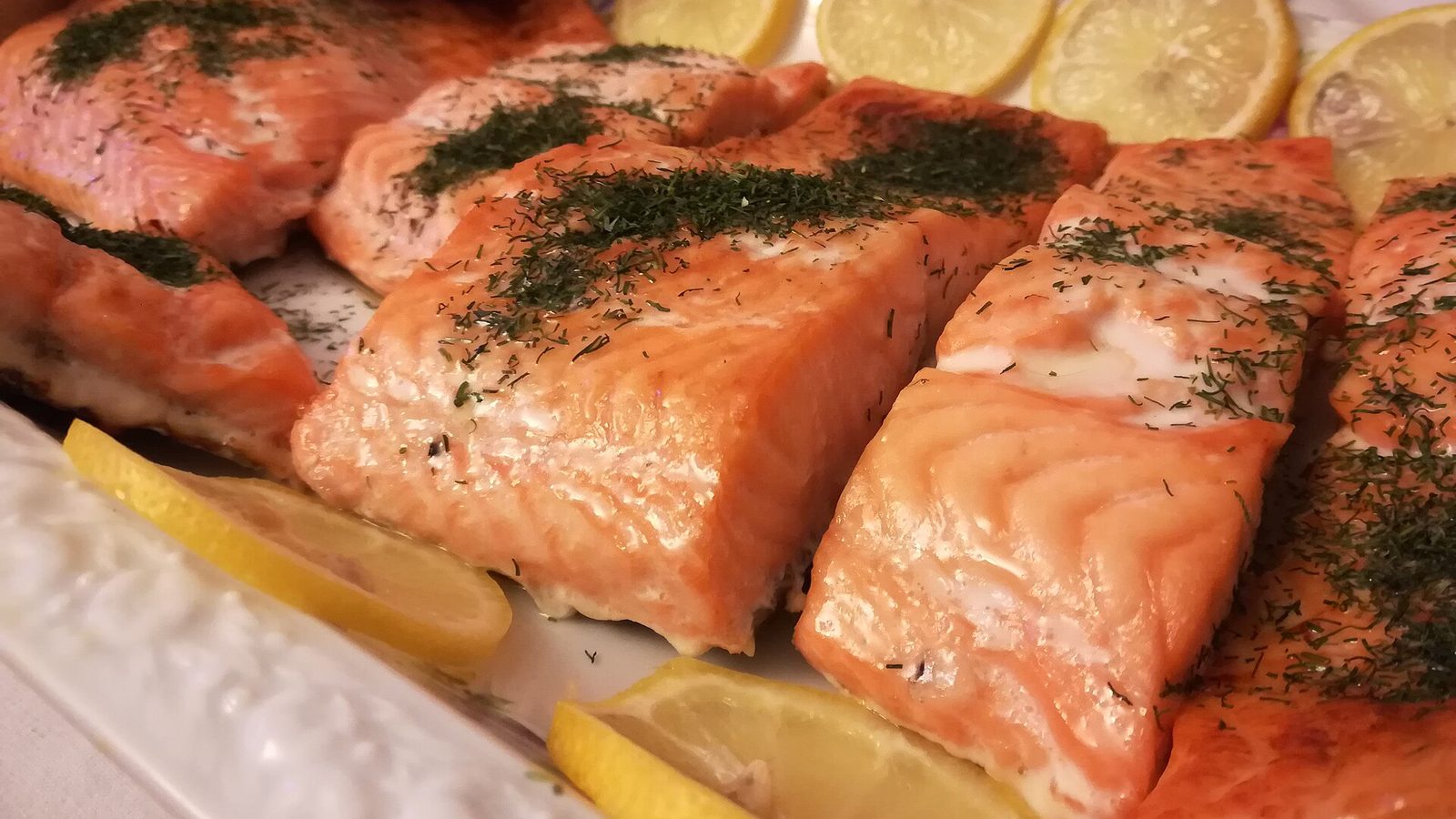 Pieczone filety z łososia z koperkiem i plasterkami cytryny na półmisku