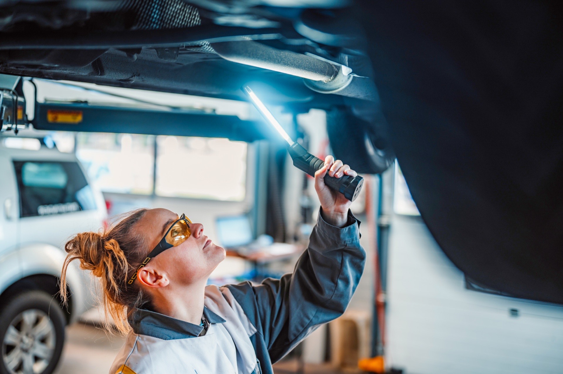 Mechanik sprawdzający podwozie samochodu podczas EU-kontroll