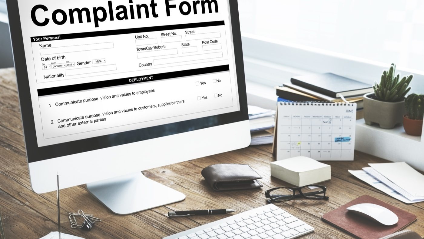 Formularz skargi wyświetlony na ekranie komputera na biurku