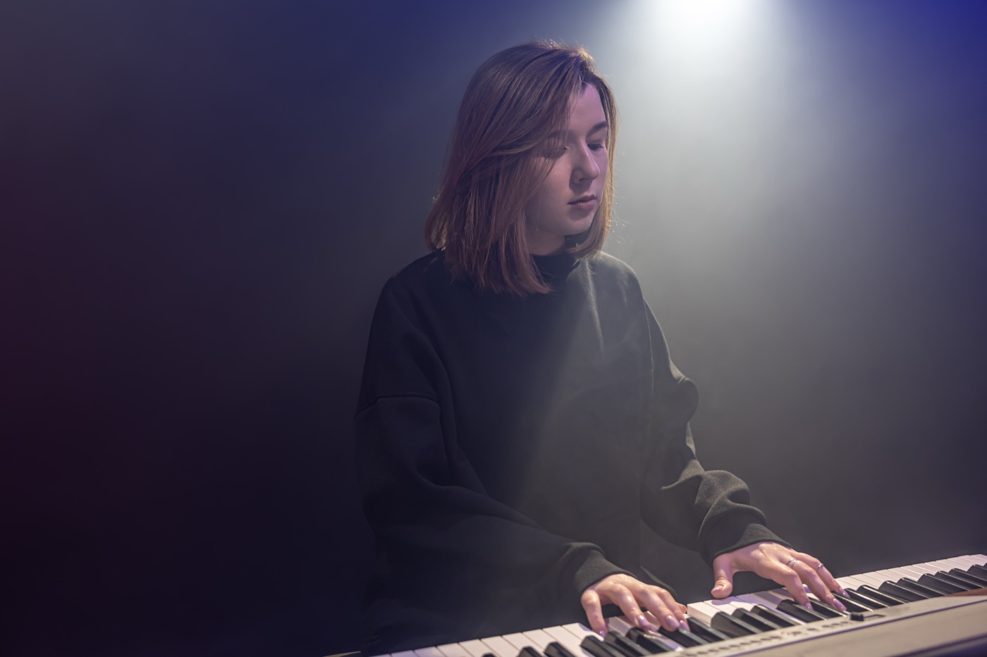 Pianistka grająca przy fortepianie w półmroku