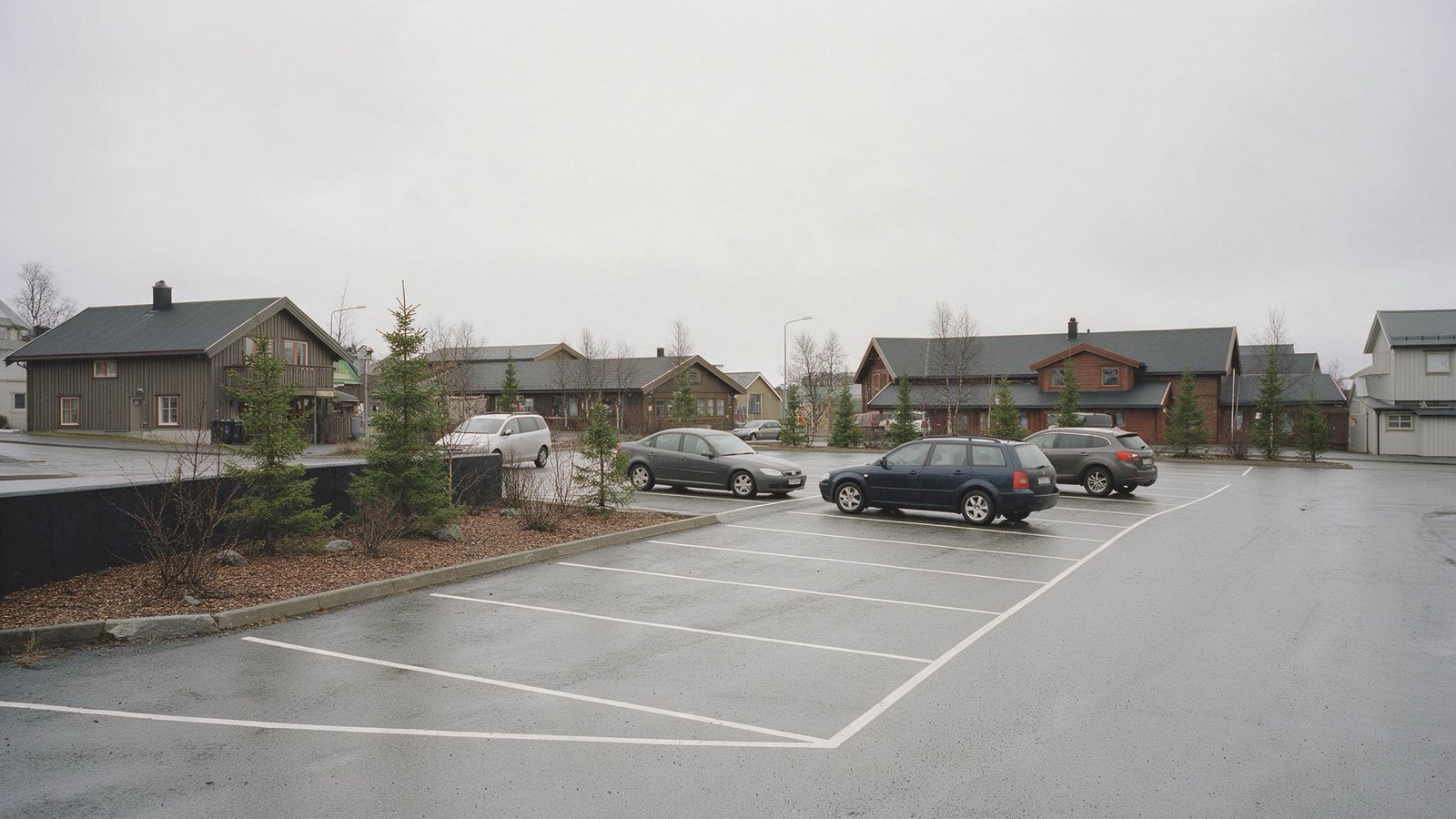 Parking miejski w Norwegii z wyznaczonymi liniami miejscami postojowymi
