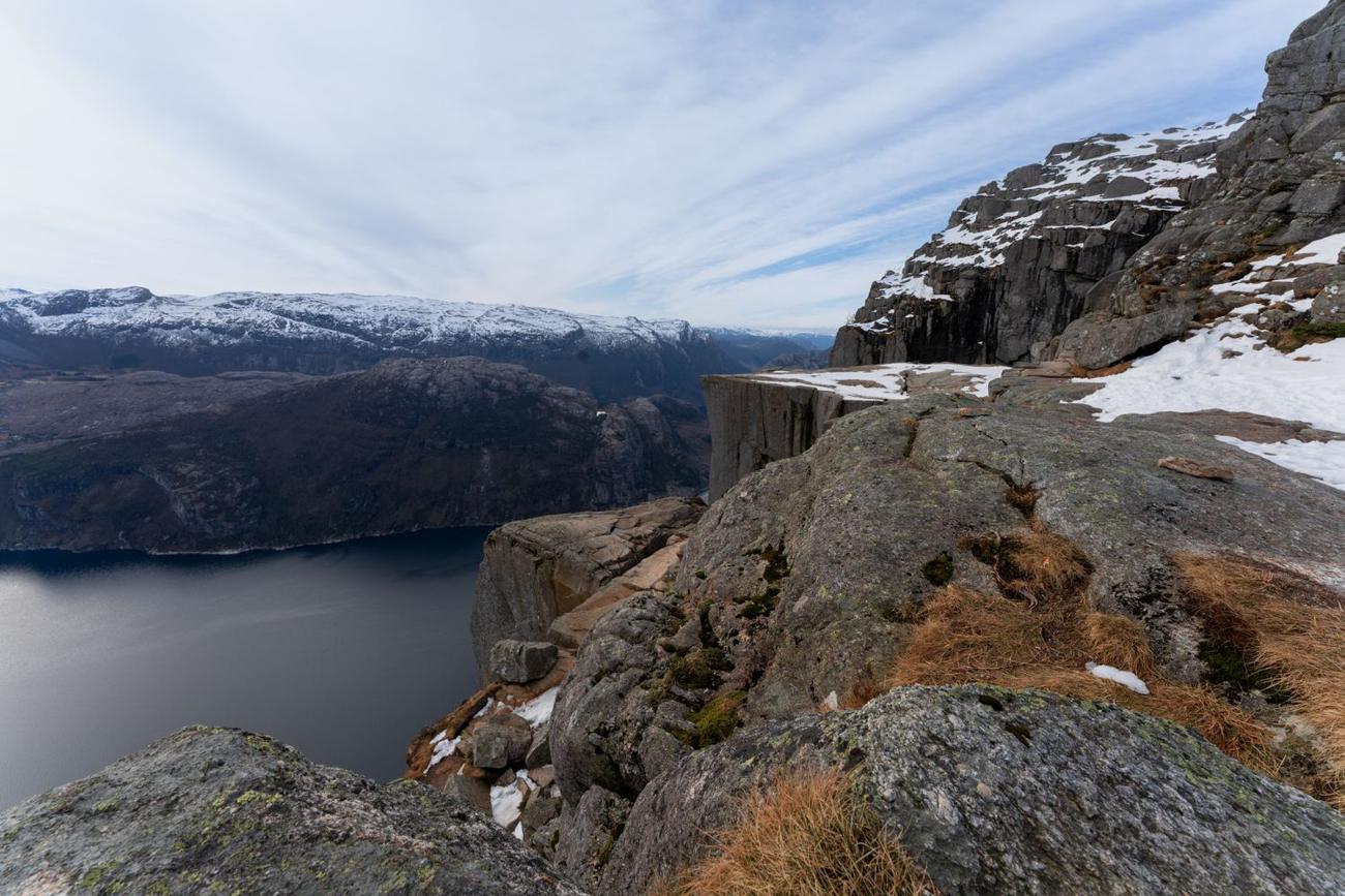 Skalna półka Preikestolen nad Lysefjordem z płatami śniegu na skałach