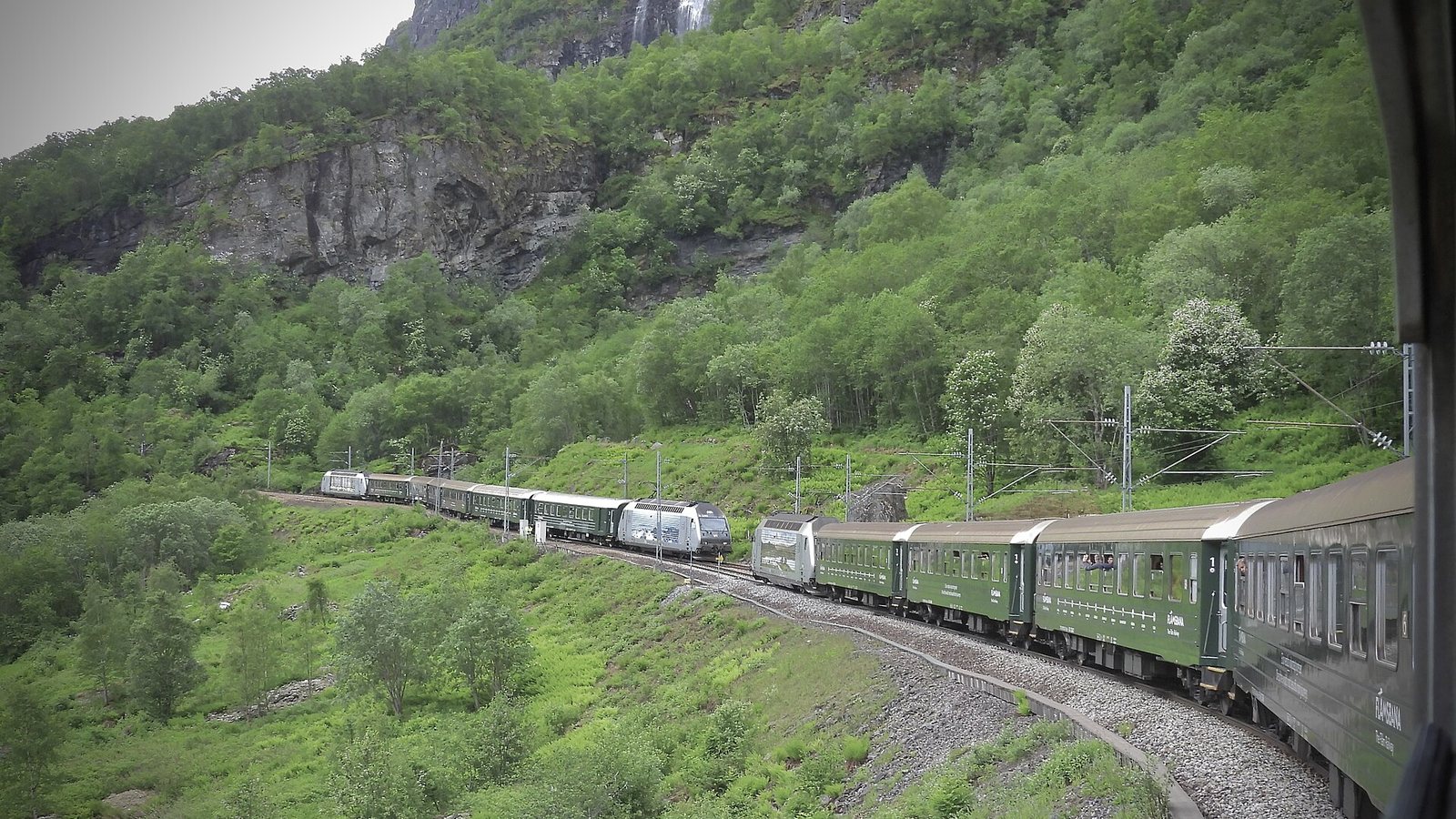 Dwa pociągi Flåmsbana mijające się na zboczu doliny Flåmsdalen