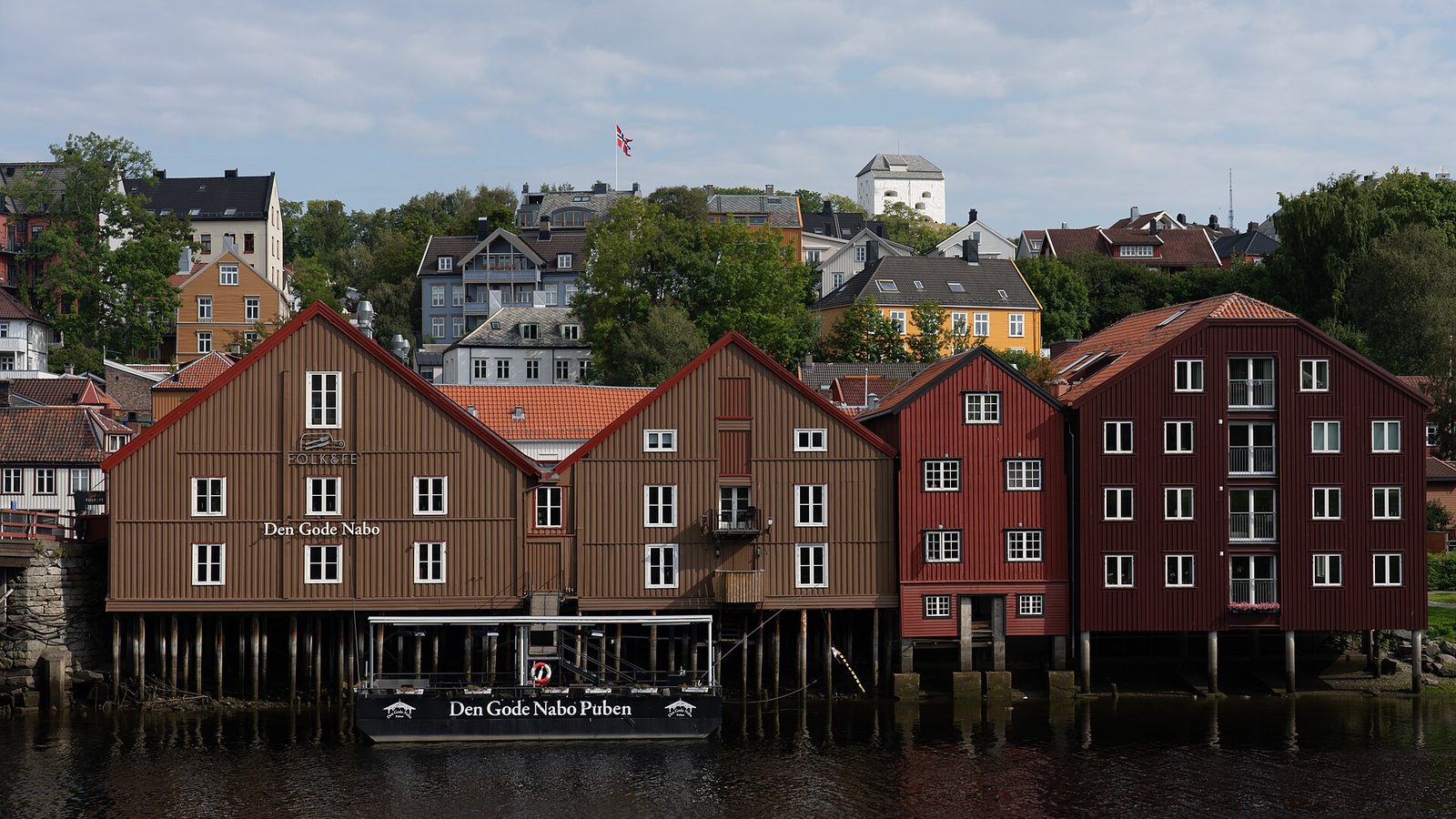 Kolorowe drewniane spichlerze na palach nad rzeką Nidelva w Trondheim